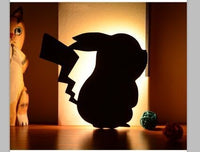 OptiLair cartoon character silhouette night light with warm yellow glow and sound-sensor activation for bedrooms