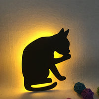 OptiLair cat-shaped acrylic night light with warm yellow sound-sensor glow for bedroom decor.