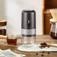 OptiLair portable electric coffee grinder in matte black with a clear powder silo and USB-C charging port.
