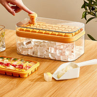 OptiLair yellow one-touch press ice cube tray and storage box set with ice shovel on a wooden table