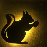 OptiLair squirrel-shaped acrylic night light with warm yellow glow and sound-sensor activation for bedroom decor.
