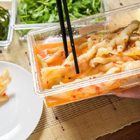OptiLair clear rectangular food storage container holding marinated chicken feet with black chopsticks