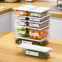 OptiLair clear stackable food storage containers with white lids, organized with fresh produce on a kitchen counter.